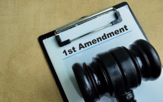 The concept of the 1st Amendment written on paperwork, isolated on a wooden background.