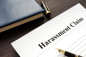 Harassment claim document and pen on a wooden desk.