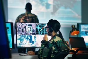 A military command center with a woman monitoring surveillance on a computer screen.