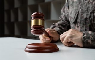 Military law concept: A soldier's hand holding a gavel.