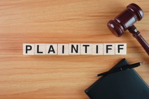 Wooden block letters spelling out "Plaintiff" on a conceptual background.