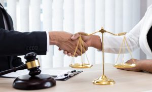 Lawyers or counselors join hands with clients to celebrate the successful resolution of a case by the company, symbolizing the negotiation or settlement of a lawsuit.